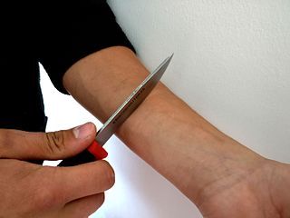 Wikimedia Commons: autolesionarse con un cuchillo por Santari Viinamaki, CC Attribution/Share Alike 4.0 International